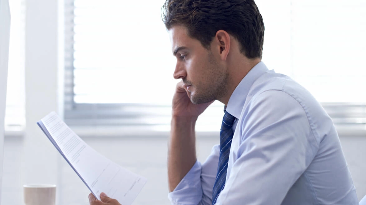Man in suit looking at piece of paper